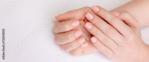 Banner cosmetic and beauty care. Stylish trendy nail young woman hands pink manicure on white background