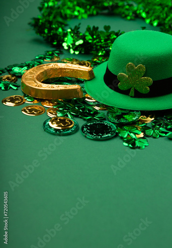 St. Patrick's Day Leprechaun Hat, Gold Coins, Shamrocks and Party Favors on Green Background.