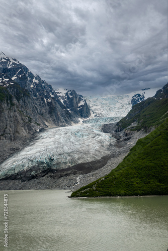 Glacier descends to Glacial Lake near north fork Crescent River and Mount Redoubt Volcano at Lake Clark National Park in Alaska. Volcanic rock (or volcanics) erupted from a volcano. photo