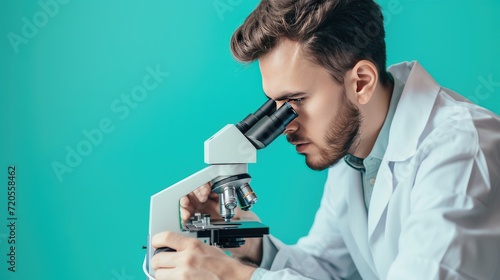 A scientist in a lab coat focusing on observing through a microscope.