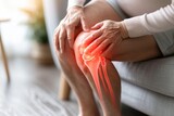Close-up of a woman gripping her knee with a red glow indicating severe pain
