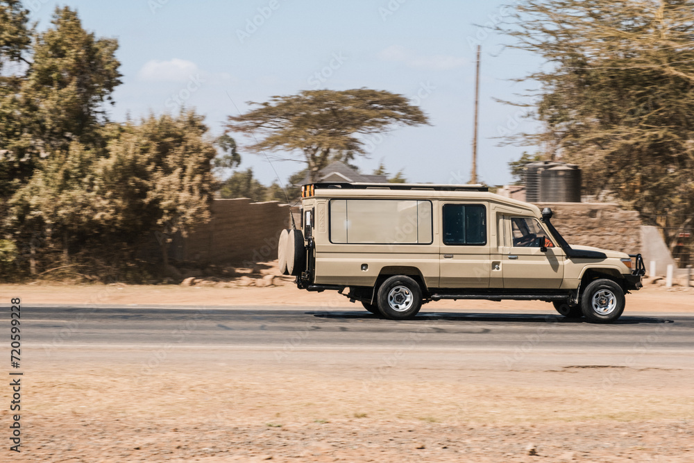 Safari jeep driving through an urban area in Africa