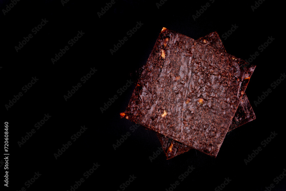 two chestnut brownies isolated on black background top view