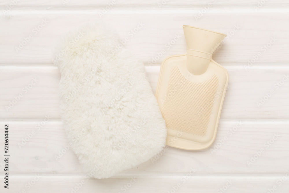 Fluffy water warmer bag on wooden background Fluffy water warmer bag on wooden background