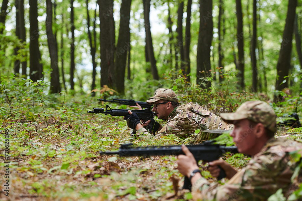 Elite soldiers stealthily maneuver through the dense forest, camouflaged in specialized gear, as they embark on a covert and strategic military mission