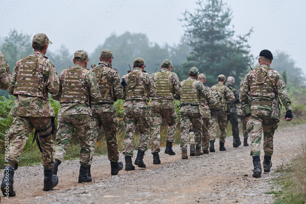 An elite military unit, led by a major, confidently parades through dense forest, showcasing precision, discipline, and readiness for high-risk operations An elite military unit, led by a major, confidently parades through dense forest, showcasing precision, discipline, and readiness for high-risk operations