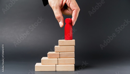 hand holding red ladder, career growth opportunities performance progress, Businessman hand placing red wooden man doll on top of ladder on black background. success business leadership