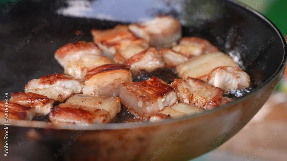 Close up of pork belly fried on a pan in slow motion Close up of pork belly fried on a pan in slow motion