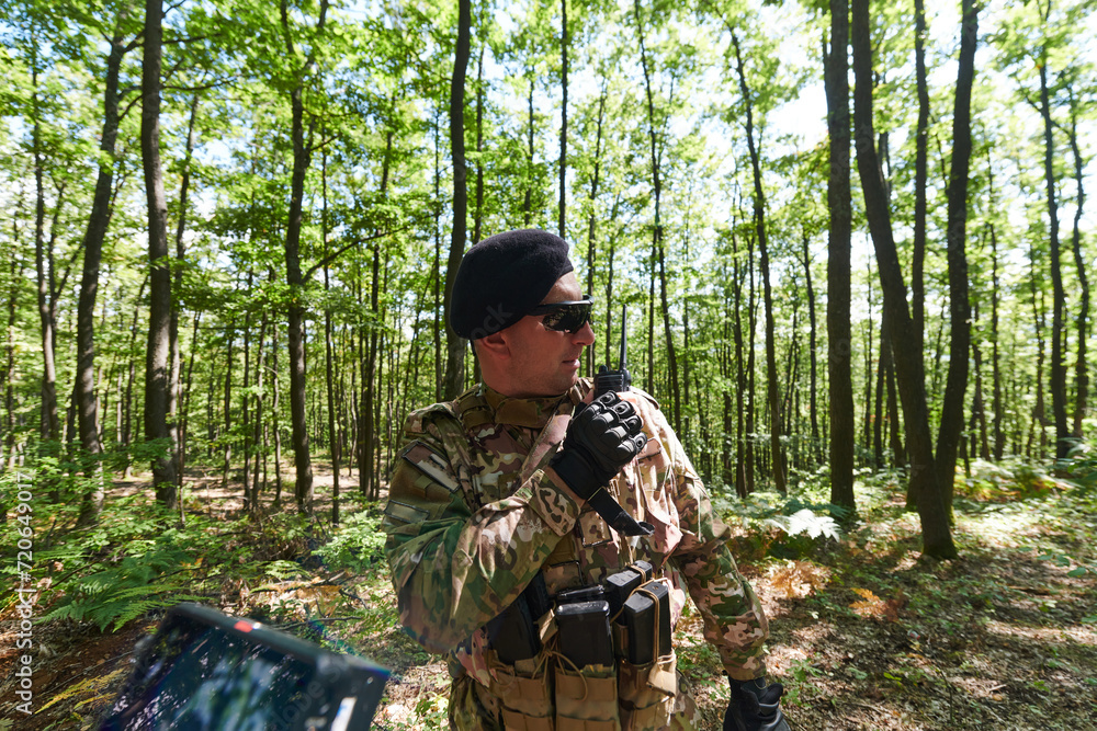 A military major employs a Motorola radio for seamless communication with his fellow soldiers during a tactical operation, showcasing professionalism and strategic coordination