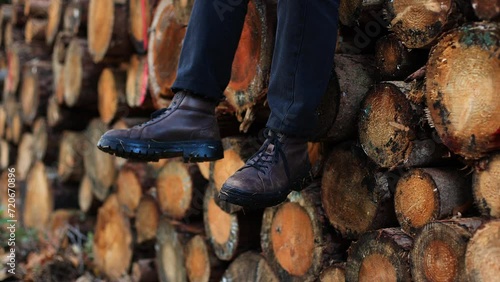 teenage tourist sits on tree in boots.lifestyle close-up legs sitting on tree 