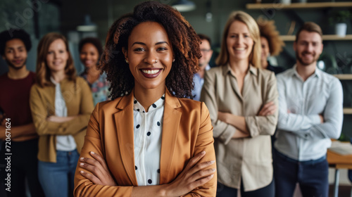 confident woman is standing in the foreground with a group of diverse people blurred in the background