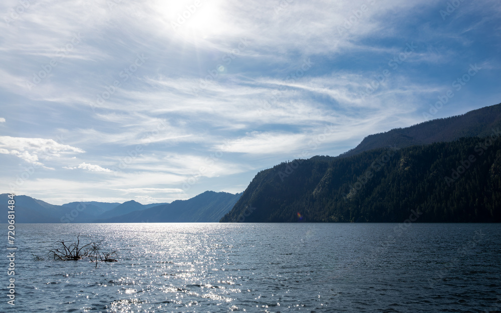 A Captivating Glimpse of Serenity Amidst Majestic Mountains, Lake, and Sky in a Timeless Landscape