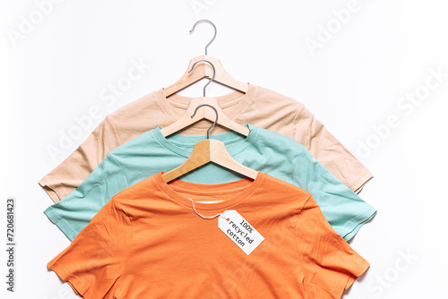Set of colorful t-shirts with empty tag and fresh green eycalyptus twig. Eco friendly organic cotton clothes concept.
 photo