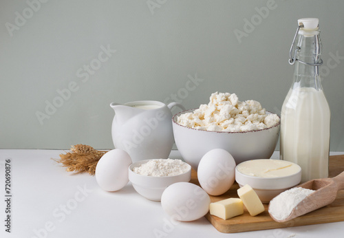 Assortment of fresh dairy products, milk, cottage cheese, cheese, cream cheese, butter, eggs and yogurt on a light background. Banner, horizontal, space for printing.