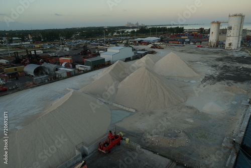 Piles of gravel and other small stones for building purposes situated in industrial zone of Nassau port in Bahamas on of the Caribbean island during sunrise.