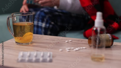 Young man takes medicine, takes pills,antibiotics from the table into his hand