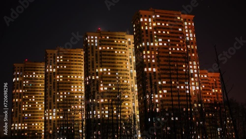 Residential complex with illumination under sky with moon. Timelapse photo