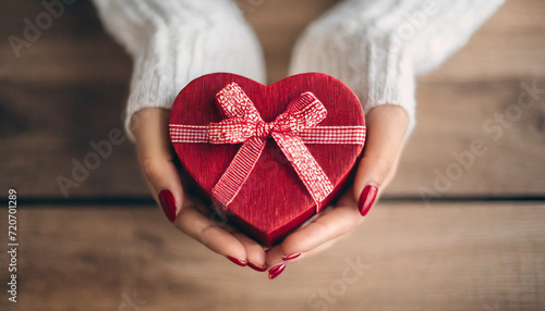 female hands cradle a heart-shaped gift, embodying love and celebration for occasions like Valentine's Day, birthdays, and Mother's Day © Your Hand Please