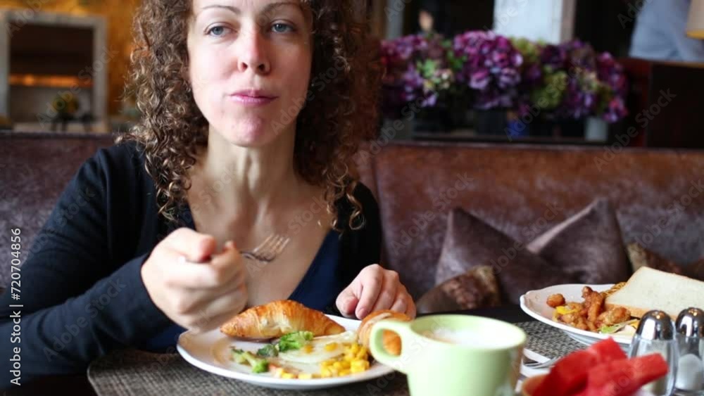 Beautiful woman eat breakfast (boiled corn and croissant) on sofa in hotel Beautiful woman eat breakfast (boiled corn and croissant) on sofa in hotel