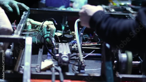Two men repairing and testing electric mechanic robot close-up. photo