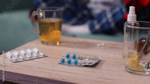 Close-up shot of pills, a man's hand takes away napkins,glasses of tea on table 