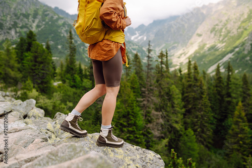 Close-up of female legs in hiking boots on a hiking trail  on top of a mountain outdoors. Travel  vacation.  The concept of nature  relaxation  walking.