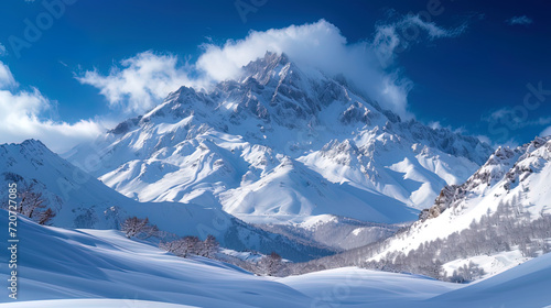 A landscape with a high mountain covered with snow, against the background of a bright blue sk