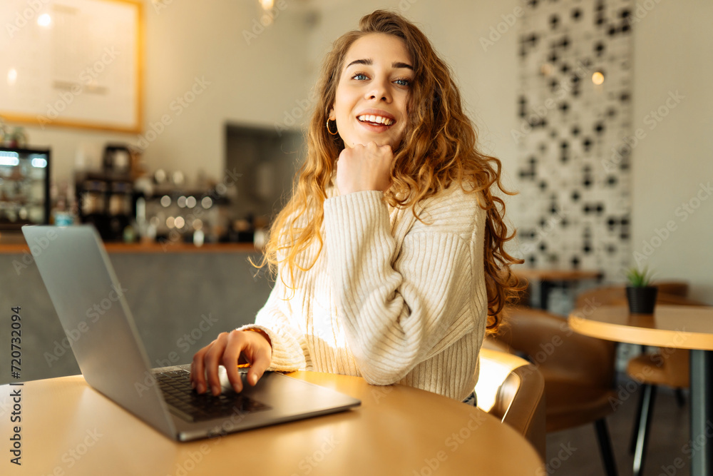 Happy woman sitting on cafe with laptop. Concept for education, business, shopping, blog or freelance. Happy woman sitting on cafe with laptop. Concept for education, business, shopping, blog or freelance.