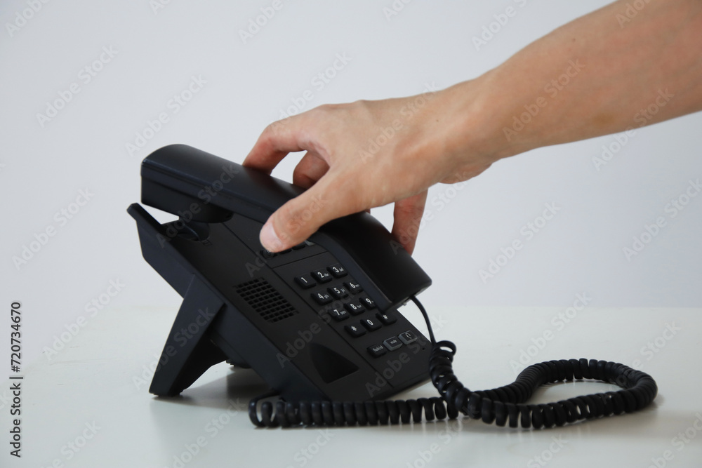 Answering the Call: Hand Holding Telephone Receiver in Communication Concept Answering the Call: Hand Holding Telephone Receiver in Communication Concept