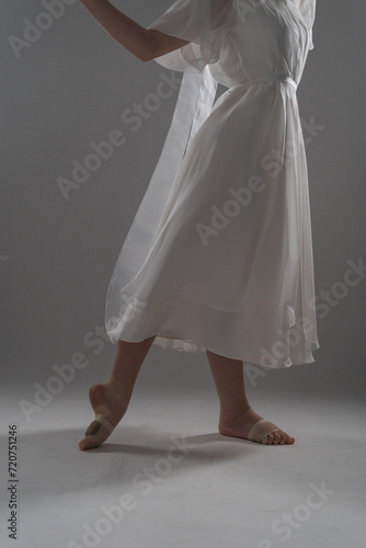 legs of a ballerina in a white dress