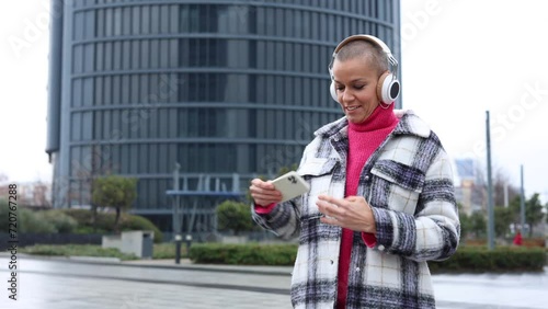 woman with cancer celebrates being a survivor by playing music and dancing in the city with skyscrapers in the background photo