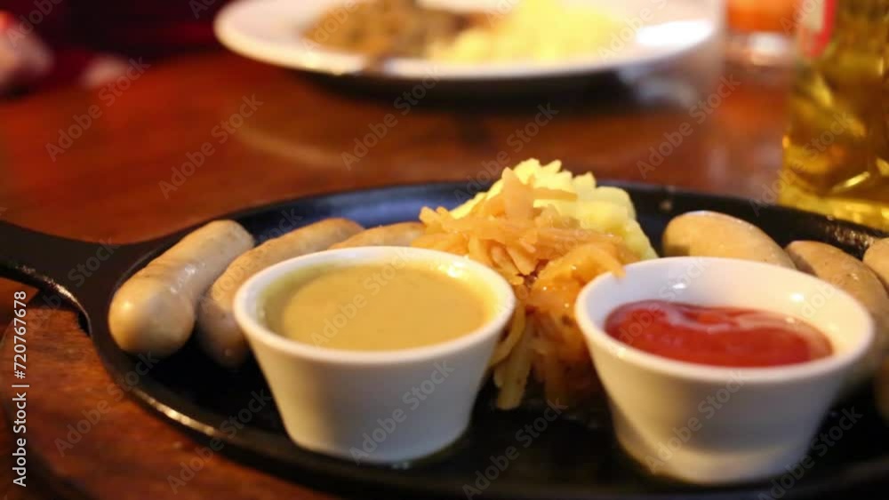 Sausages, mashed potatoes, sauces, beer on table in restaurant Sausages, mashed potatoes, sauces, beer on table in restaurant