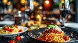 A plate of spaghetti with tomato sauce and a glass of wine. Perfect for Italian cuisine or food and drink concepts