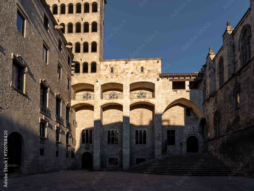 Edificio de estilo gótico de piedra con escaleras, torre y arcos