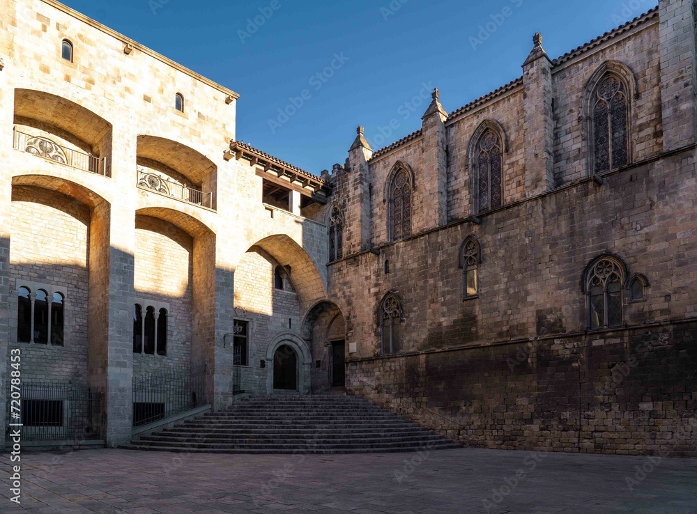 Edificio de estilo gótico de piedra con escaleras, torre y arcos