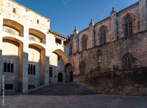 Edificio de estilo gótico de piedra con escaleras, torre y arcos