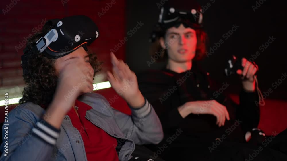 Close-up. Having finished playing, two teenagers take off their VR glasses and make a gimme five gesture with their hands. The guys are happy and smiling Close-up. Having finished playing, two teenagers take off their VR glasses and make a gimme five gesture with their hands. The guys are happy and smiling