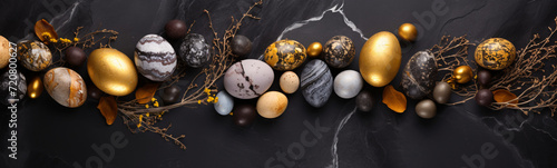 Osterdekoration mit edlen, goldenen Eiern auf dunklem Schieferhintergrund