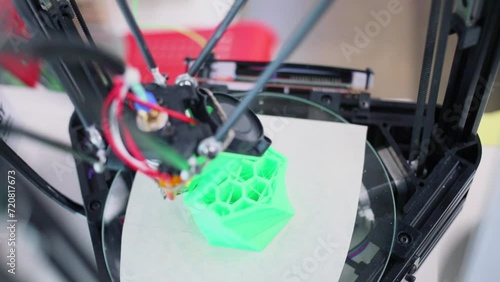 3D printer makes green plastic form with cells, closeup photo