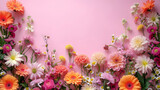 A vibrant and diverse collection of flowers forms a natural border around a pastel pink backdrop, creating a delicate and inviting space for various design purposes