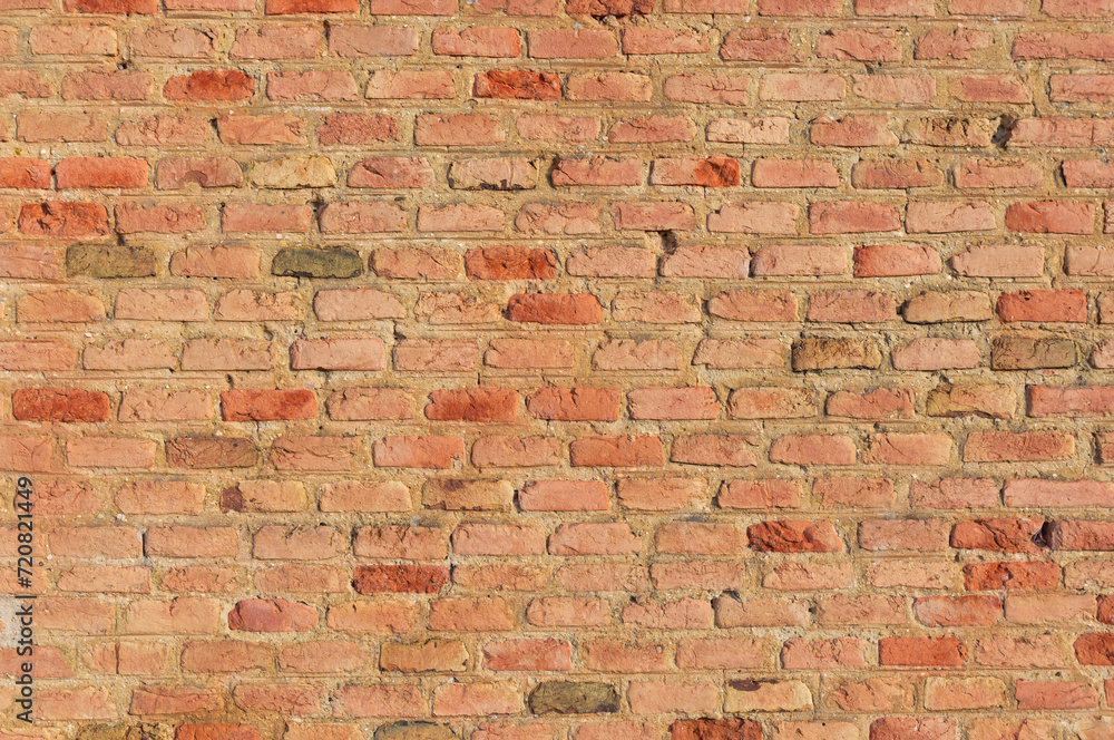 Naklejka premium Warm Glow: Salmon-Colored Brick Wall Background.