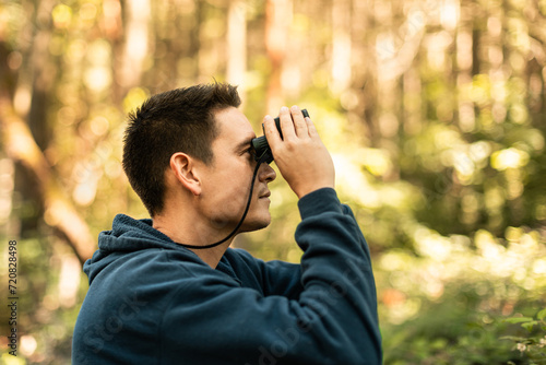 Wall Mural man with binoculars in the forest exploring discovering nature hobby wildlife
