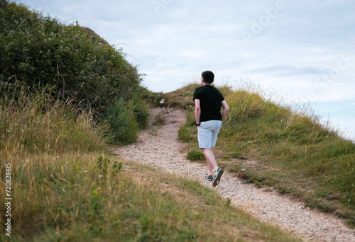 A young man climbs to the top of the mountain.