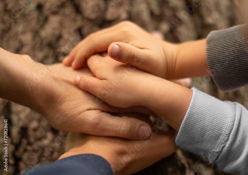 Parents and children family hands together resting on tree trunk. Love and protect nature concept. family together unity concept. 