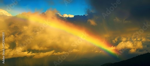Mesmerizing Rainbow Over Clouds in the Rainy Season: A Captivating Visual Display of Rainbow, Clouds, and Rainy Season Delights