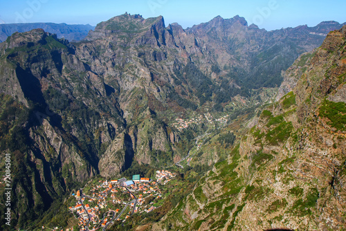 View of the village of Curral das Freiras (Corral of the Nuns) overlooked by the Pico Grande summit from the Miradouro do ParedÃ£o viewpoint in the Valley of the Nuns on Madeira island, Portugal photo