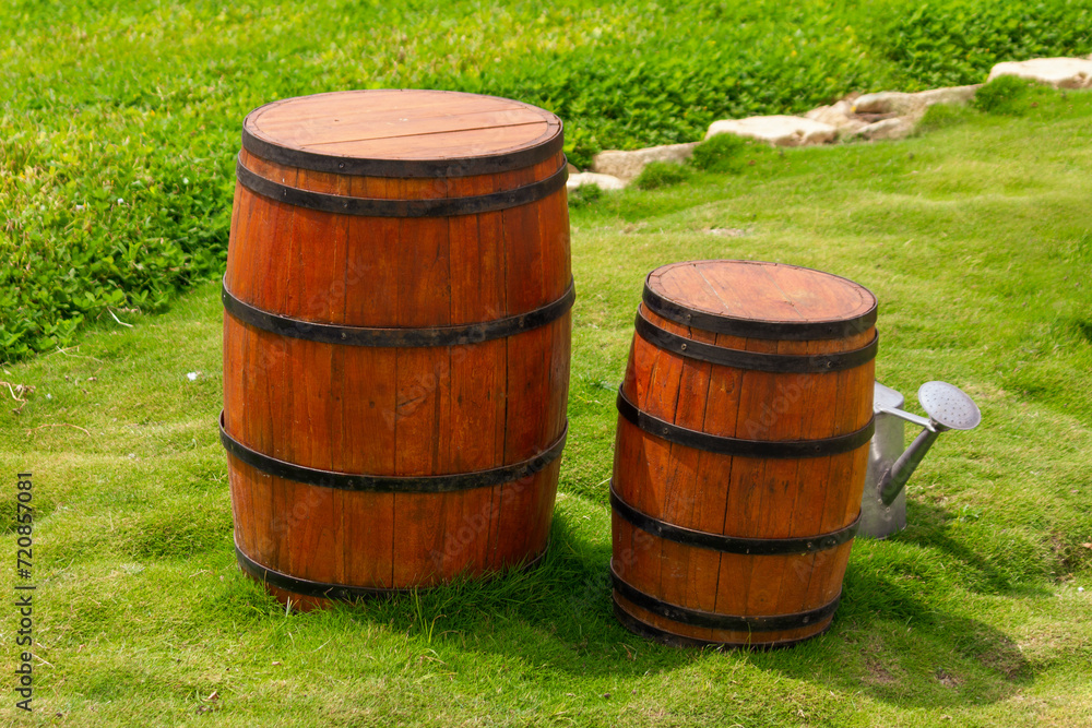 Old fashioned antique whisky wood barrel and wine container on the grass Old fashioned antique whisky wood barrel and wine container on the grass