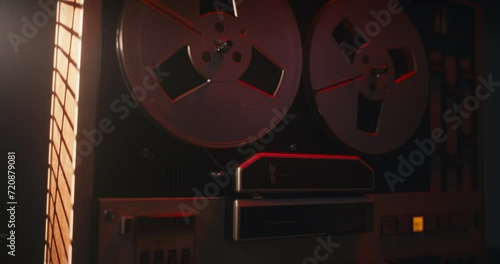 A close-up of the retro-style spool tape recorder in the red blinking light