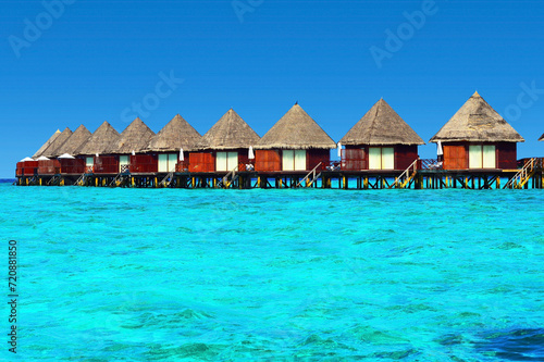 Water villas stand abreast in Maldivian sea 1