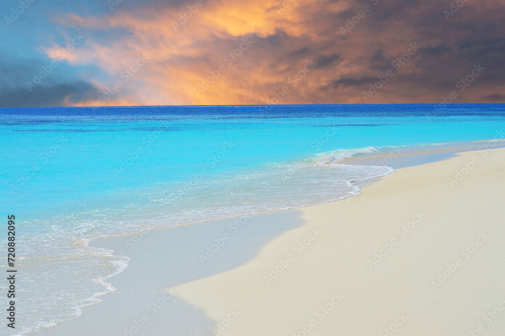 Fotografie Waves on beach in Maldivian sea under dramatic sky